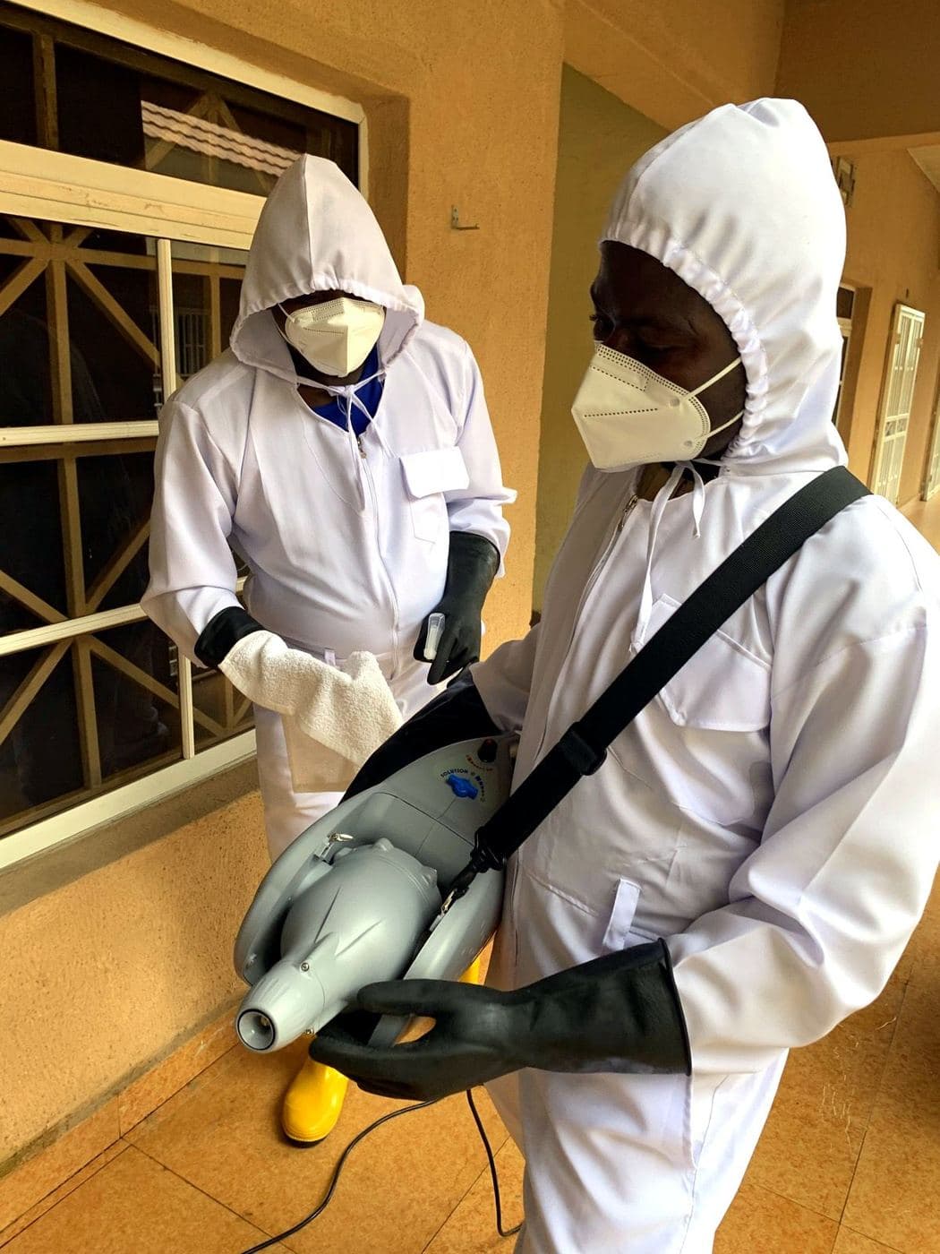 Two White Wall crew members in protective suits with a fogger