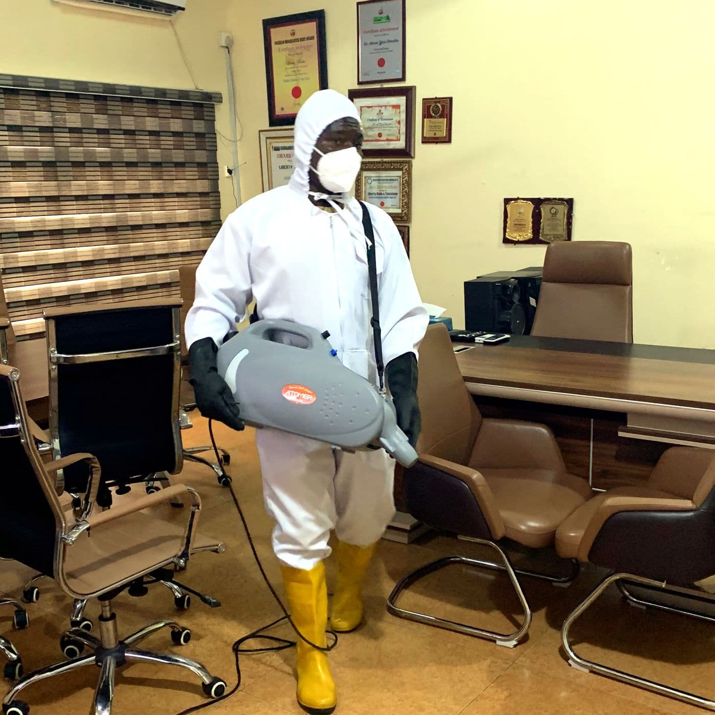 A White Wall crew member disinfecting a director's office